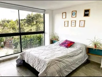 a bedroom with a bed and a large window at Villa cerca al aeropuerto in Guarne