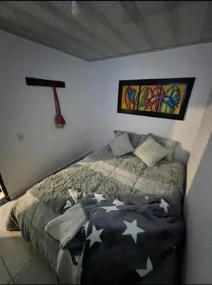 a bedroom with a bed and a painting on the wall at Villa Guarne Merlot in Guarne