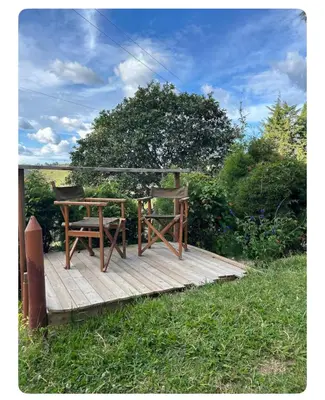 a wooden deck with a table and a chair on it at Villa Guarne Merlot in Guarne
