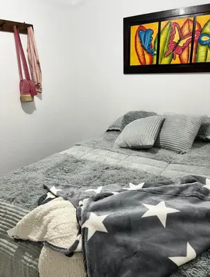 a bed with a blanket with stars on it at Villa Guarne Merlot in Guarne