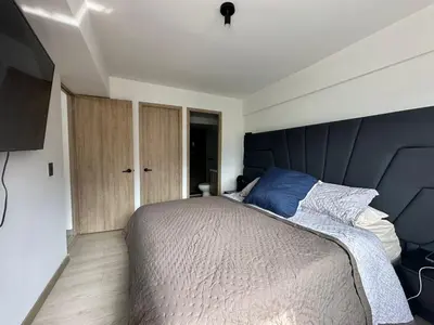 a bedroom with a large bed with a blue headboard at apartamento familiar de 3 habitaciones por meses in La Estrella