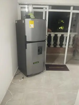 a refrigerator sitting in a room with a window at Tu Lugar ideal in Envigado