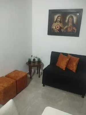 a living room with a black couch and a table at Tu Lugar ideal in Envigado