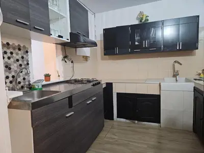 a kitchen with black cabinets and a sink at KaVal in Jardin