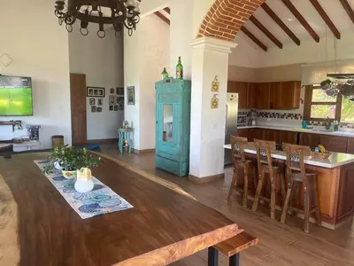 a kitchen with a wooden table and a kitchen with a bar at Casa colonial hermosa divisa a 1 45 h de Medellin in Venecia