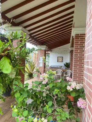 a patio with flowers and tables and chairs at Casa colonial hermosa divisa a 1 45 h de Medellin in Venecia