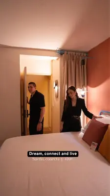 a man and woman standing next to a bed at Autenthico Provenza Home Medellin in Medellín