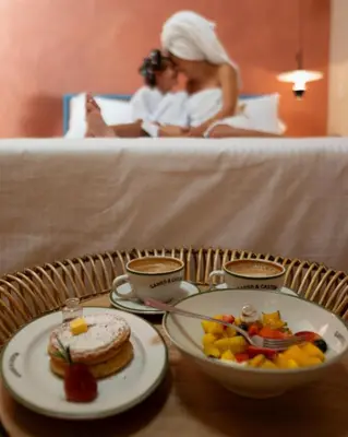 a table with a plate of food on a bed at Autenthico Provenza Home Medellin in Medellín