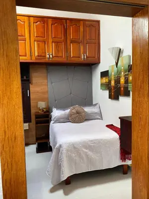 a bedroom with a bed and wooden cabinets at Casa Tobi in Rionegro
