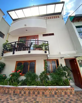 a white house with a balcony and plants at Casa Tobi in Rionegro