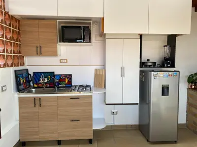 a kitchen with white cabinets and a stainless steel refrigerator at Casa Tobi in Rionegro