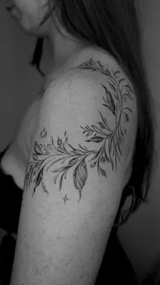 a woman with a feather tattoo on her shoulder at Kintin Tattoo Hostel in Jardin