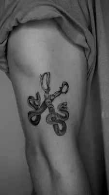 a tattoo of a pair of scissors on the side of a woman at Kintin Tattoo Hostel in Jardin