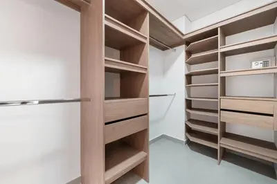 a walk in closet with white walls and wooden shelves at Poblado Apt with King bed and Free parking 216 in Medellín