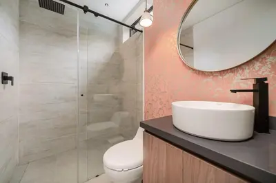 a bathroom with a toilet and a sink and a mirror at Poblado Apt with King bed and Free parking 216 in Medellín