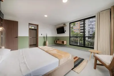 a bedroom with a large bed and a large window at Poblado Apt with King bed and Free parking 216 in Medellín