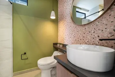 a bathroom with a sink and a toilet and a mirror at Poblado Apt with King bed and Free parking 216 in Medellín