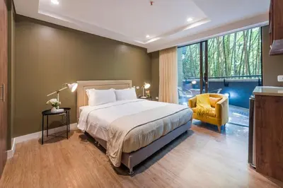 a bedroom with a large bed and a yellow chair at DUP 315 Tesoro - Cls in Medellín
