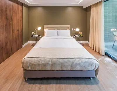 a bedroom with a bed and two tables with lamps at DUP 315 Tesoro - Cls in Medellín