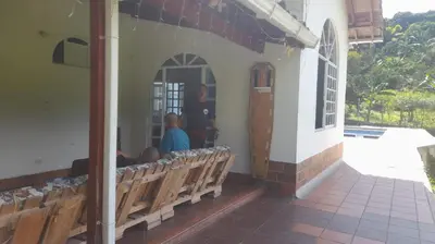 a group of people sitting on benches outside of a building at Casa de Pacho in Bello