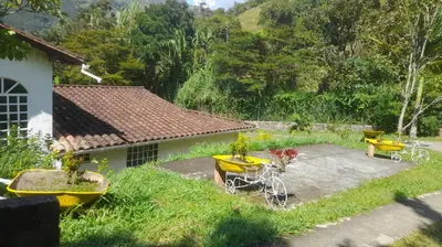 a patio with a table and chairs and a house at Casa de Pacho in Bello