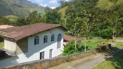 a small white house with mountains in the background at Casa de Pacho in Bello