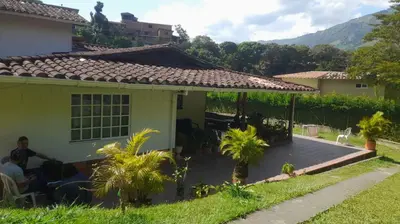 a house with a pergola in the yard at Casa de Pacho in Bello