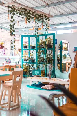 a restaurant with tables and chairs and plants on the wall at Índigo Cowork in San Rafael
