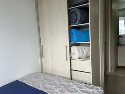 a bedroom with a bed and a closet with towels at Apartamento TERMINAL DE TRANSPORTE, CABLE AEREO, DOLLARCITY, D1 in Manizales