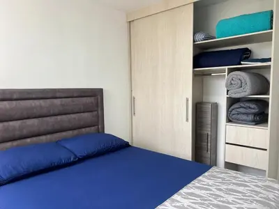 a bedroom with a blue bed and a closet at Apartamento TERMINAL DE TRANSPORTE, CABLE AEREO, DOLLARCITY, D1 in Manizales