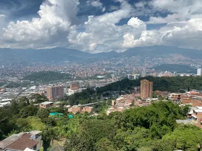 a view of a city with buildings and mountains at Apartamento alto de palmas 1 in Medellín