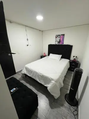 a bedroom with a white bed and a speaker at Apartamento alto de palmas 1 in Medellín