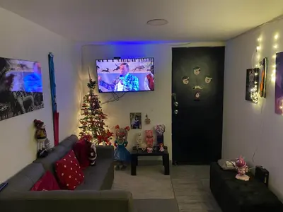 a living room with a christmas tree and a television at Apartamento alto de palmas 1 in Medellín