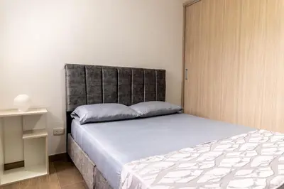 a bedroom with a large bed with a gray headboard at Apartamento via TERMALES Y LOS NEVADOS in Manizales
