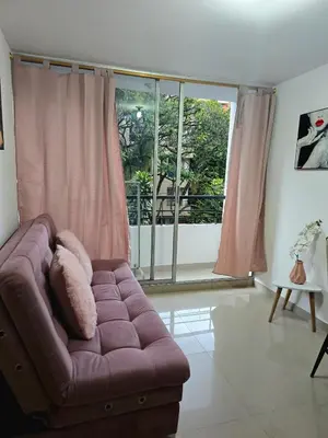 a living room with a couch and a large window at Cálido y moderno lugar Sabaneta in Sabaneta