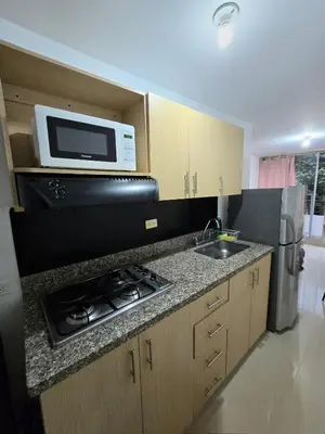 a kitchen with a microwave and a stove and a sink at Cálido y moderno lugar Sabaneta in Sabaneta