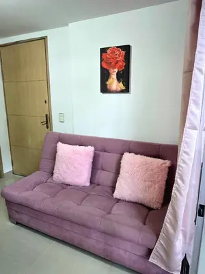 a purple couch with two pink pillows in a living room at Cálido y moderno lugar Sabaneta in Sabaneta
