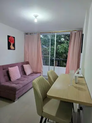 a living room with a purple couch and a table at Cálido y moderno lugar Sabaneta in Sabaneta