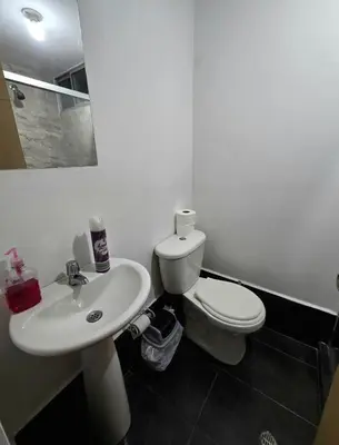 a bathroom with a white toilet and a sink at Cálido y moderno lugar Sabaneta in Sabaneta