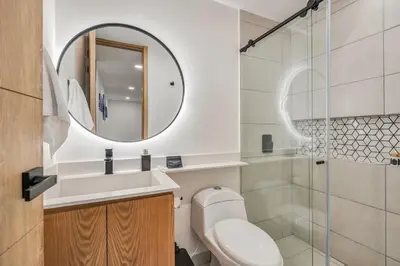a bathroom with a toilet and a sink and a mirror at Opulent and Luxury 4 Bedroom in Sabaneta