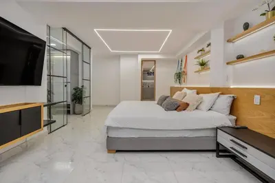 a bedroom with a large bed and a flat screen tv at Opulent and Luxury 4 Bedroom in Sabaneta