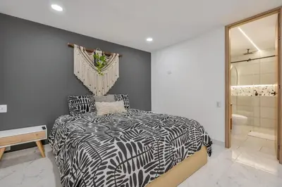 a bedroom with a black and white bed and a bathroom at Opulent and Luxury 4 Bedroom in Sabaneta
