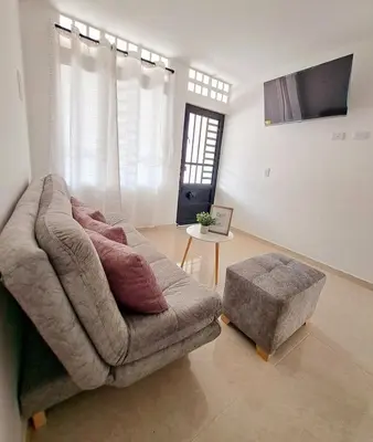 a couch and a ottoman in a living room at Casa del Sol in Mariquita