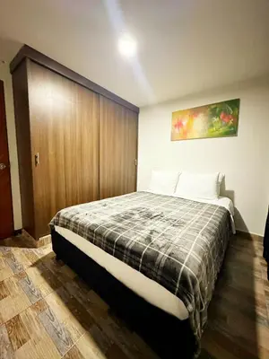a bedroom with a bed and a wooden wall at Apartamento 2 habitaciones Viva Envigado in Envigado