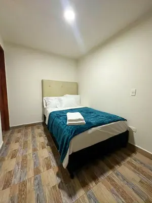 a small bedroom with a bed with a blue blanket at Apartamento 2 habitaciones Viva Envigado in Envigado