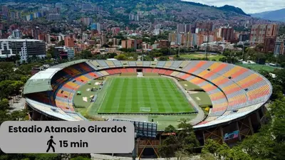 an empty soccer stadium with a city in the background at Excelente Ubicación en La 70-Laureles in Medellín