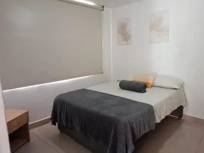 a small bedroom with a bed with a gray blanket at Excelente Ubicación en La 70-Laureles in Medellín