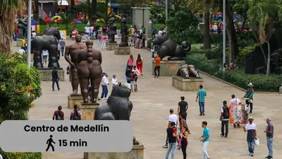 a group of people walking around a park with a statue at Excelente Ubicación en La 70-Laureles in Medellín