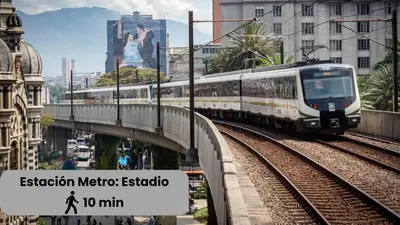 a train on a bridge in a city at Excelente Ubicación en La 70-Laureles in Medellín