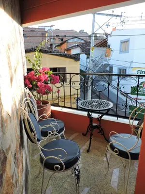 a balcony with three chairs and a table on a balcony at Hotel La Casona Ituango in Ituango